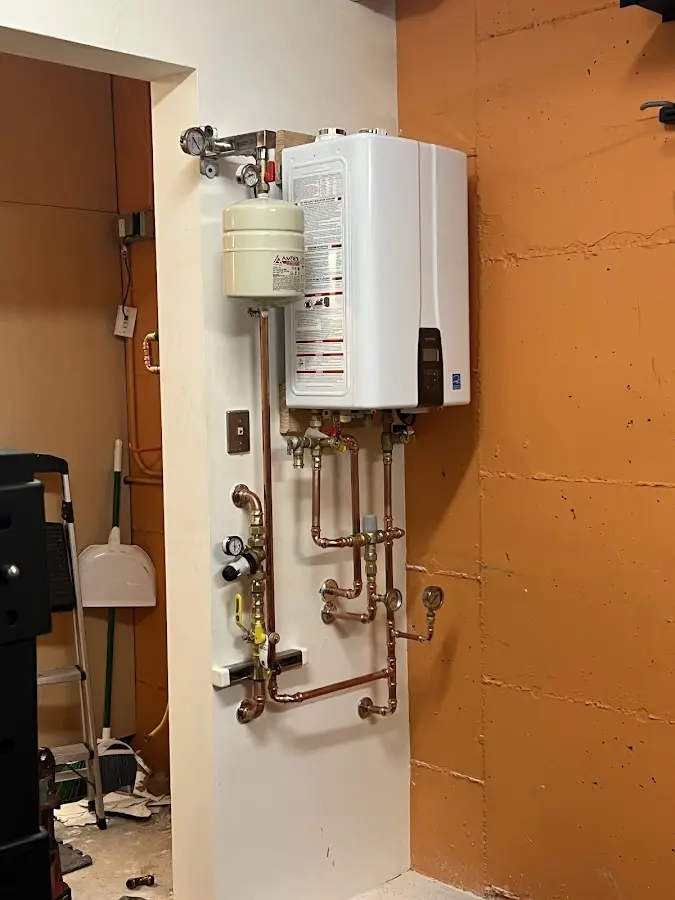 Plumbing technician inspecting water heater connections in San Marino